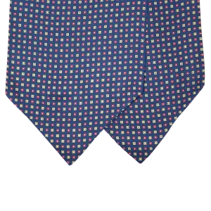 Dettaglio delle due pale di un ascot in seta blu navy con motivi quadrati alternati rosso rubino e giallo oro