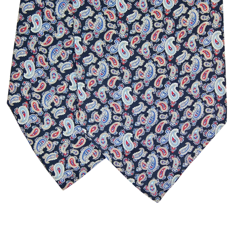 Dettaglio delle pale di un ascot in seta blu scuro con piccoli motivi paisley azzurri, rossi e crema
