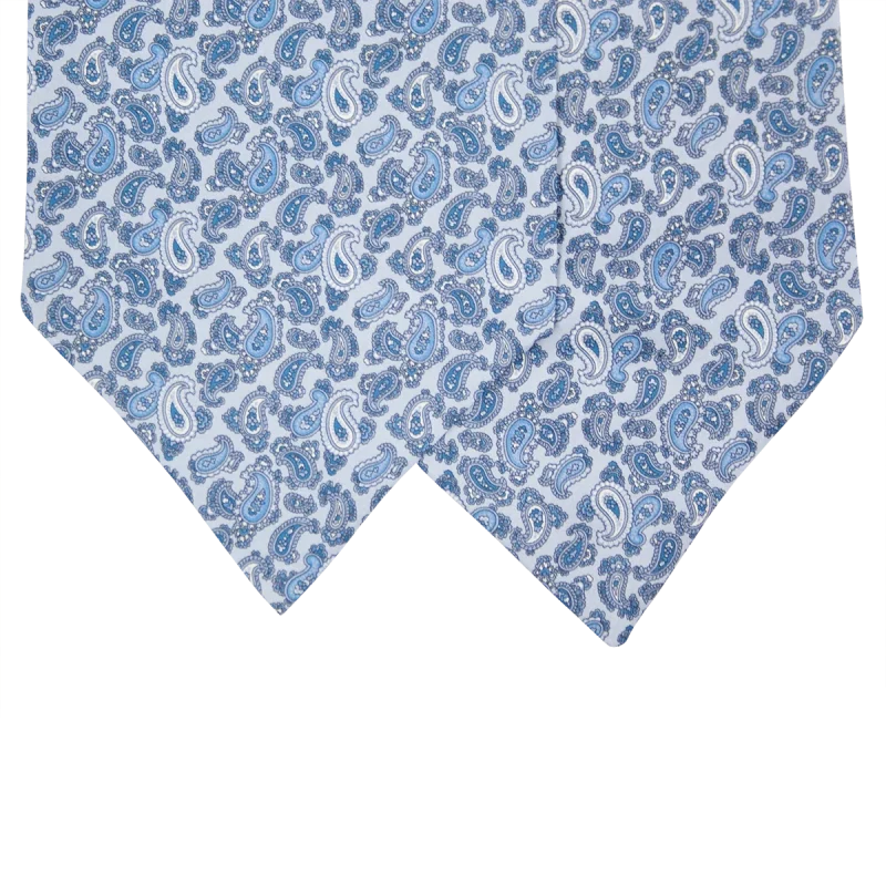 Dettaglio delle due pale di un ascot in seta azzurro chiaro con motivi paisley blu, azzurri e bianchi