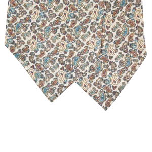 Dettaglio delle due pale di un ascot in seta beige chiaro con motivi paisley azzurri, blu e ruggine