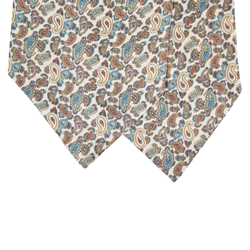 Dettaglio delle due pale di un ascot in seta beige chiaro con motivi paisley azzurri, blu e ruggine