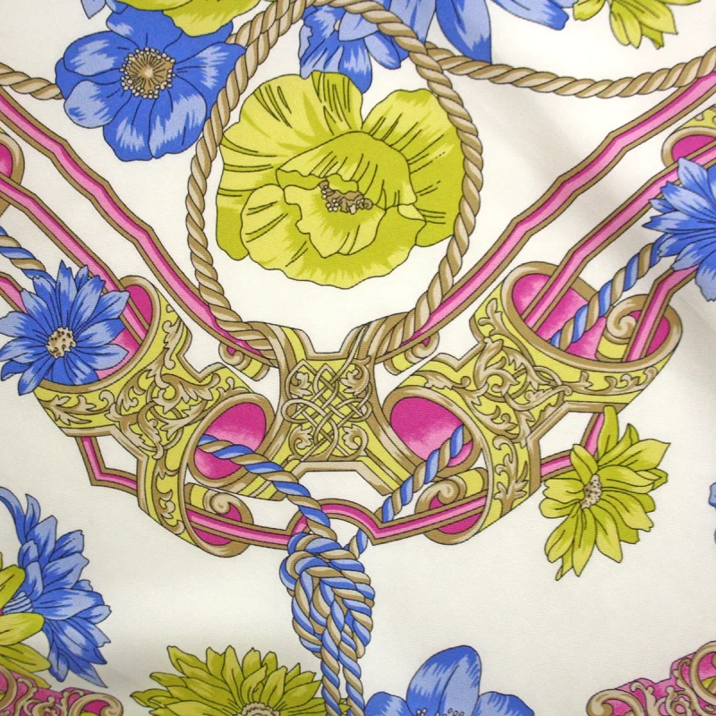 dettaglio di foulard in seta con fiori blu e verdi corde e motivi ornamentali rosa