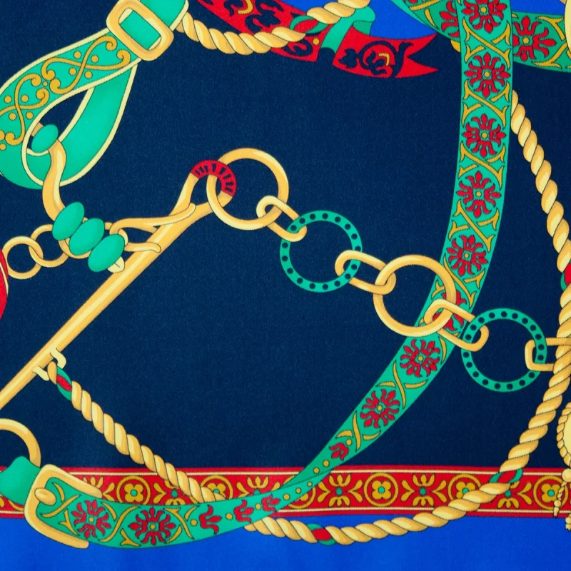 Dettaglio stampa foulard in seta con catene decorative e motivi ornamentali blu e verde