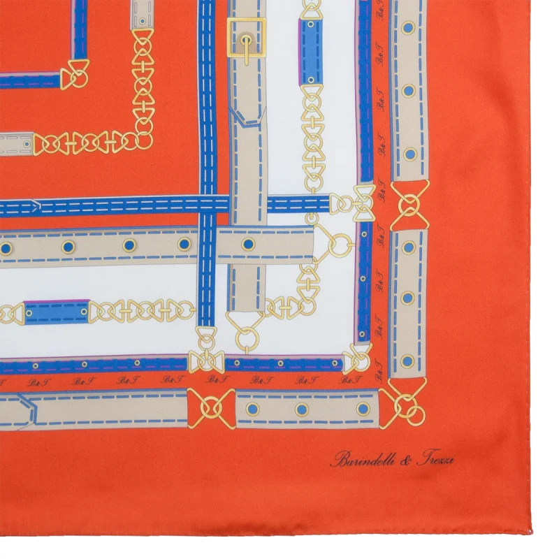 Dettaglio stampa foulard seta arancione intenso con fibbie e catene decorative
