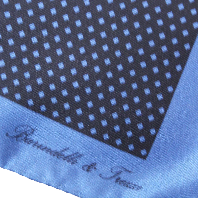 Dettaglio fantasia geometrica a quadri su pochette da taschino in seta blu e carta da zucchero