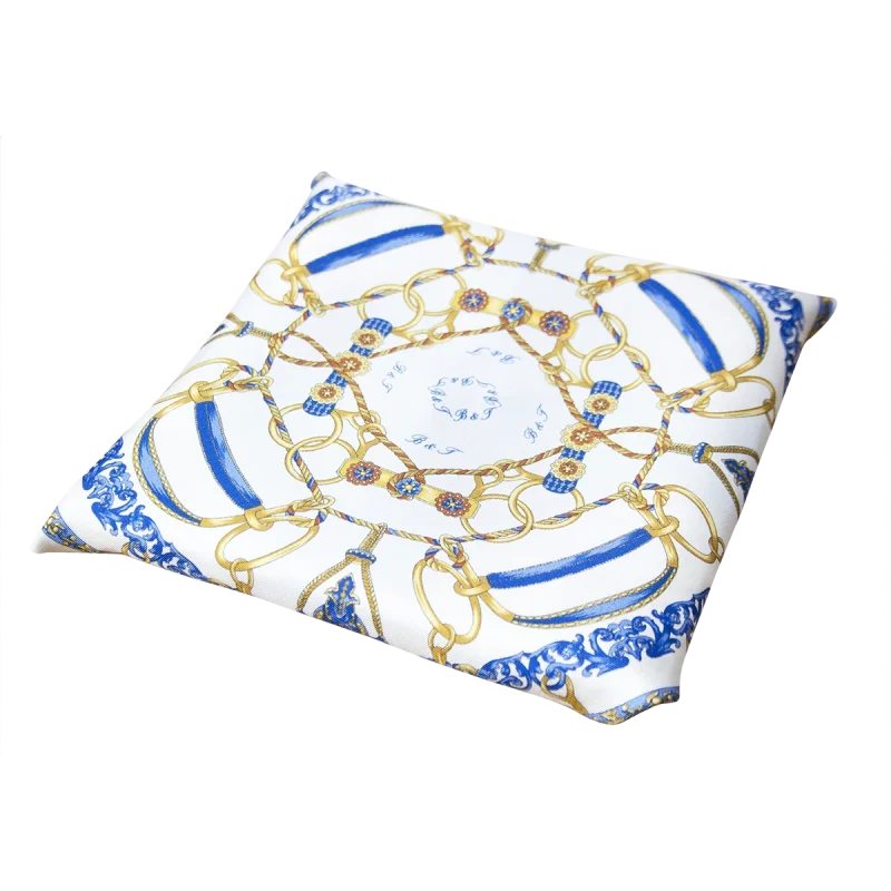 Foulard piccolo in seta piegato con stampa catene, fondo chiaro e bordo blu acceso