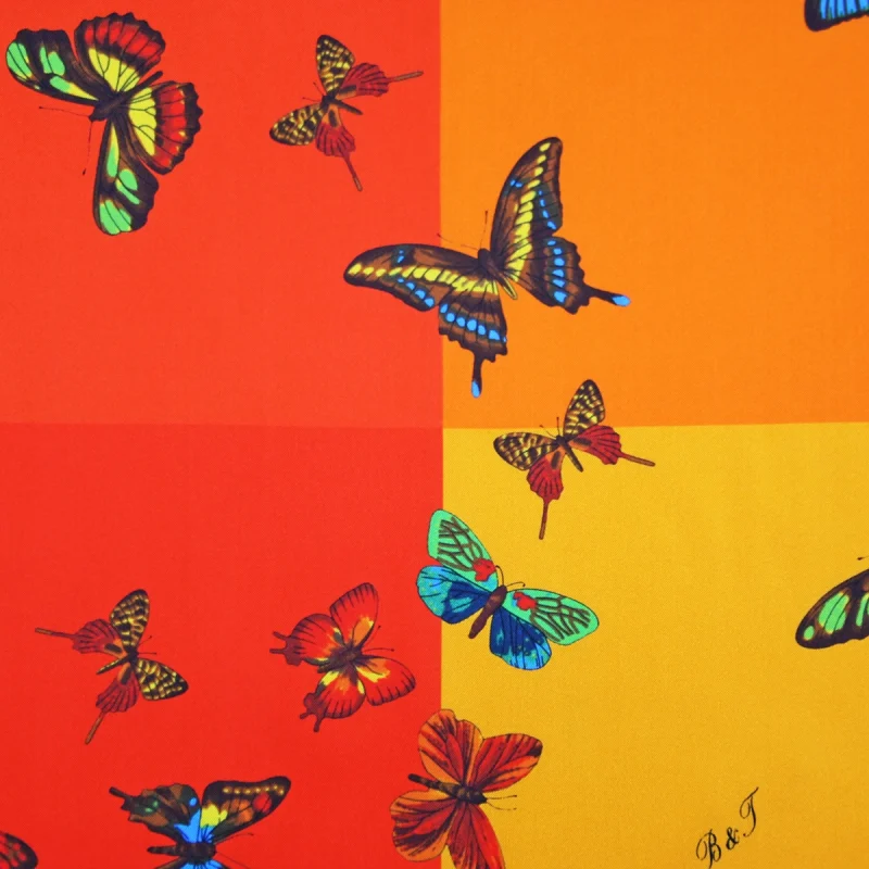 foulard in seta multicolore con farfalle su fondo rosso arancio e giallo