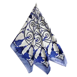 foulard in seta drappeggiato con corde e nappine blu su fondo chiaro