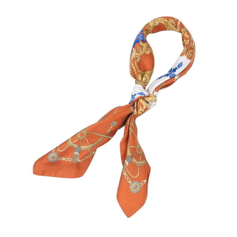 foulard in seta arancio annodato con decorazioni dorate e particolari azzurri