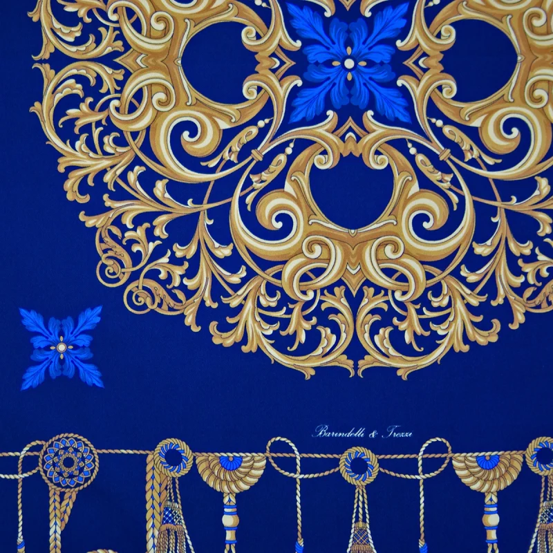 dettaglio del foulard in seta blu royal con motivi ornamentali dorati