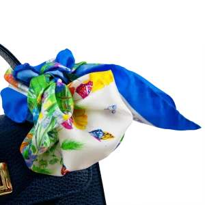 Dettaglio di foulard piccolo in seta blu chiaro con fantasia floreale e farfalle