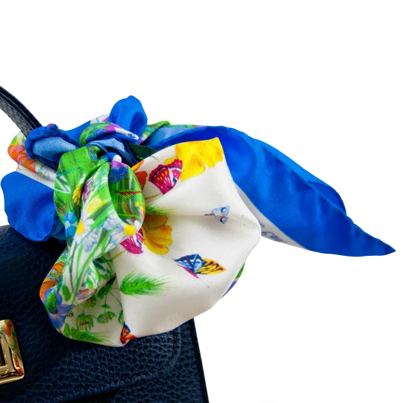 Dettaglio di foulard piccolo in seta blu chiaro con fantasia floreale e farfalle