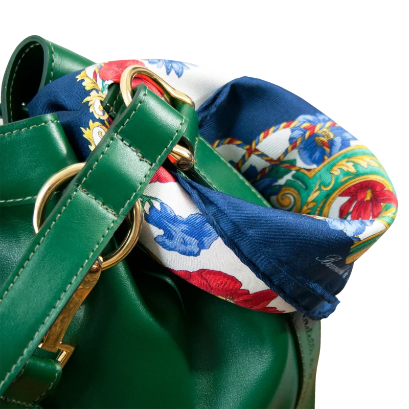 Foulard piccolo in seta blu floreale annodato su borsa verde in pelle