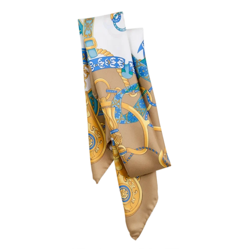 Dettaglio foulard in seta di Como con fantasia catene e nastri nei toni sabbia dorata e azzurro
