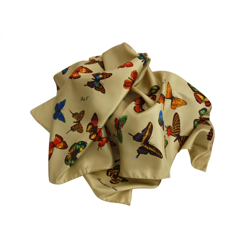 foulard in seta beige sabbia con fantasia farfalle disposto in morbido drappeggio