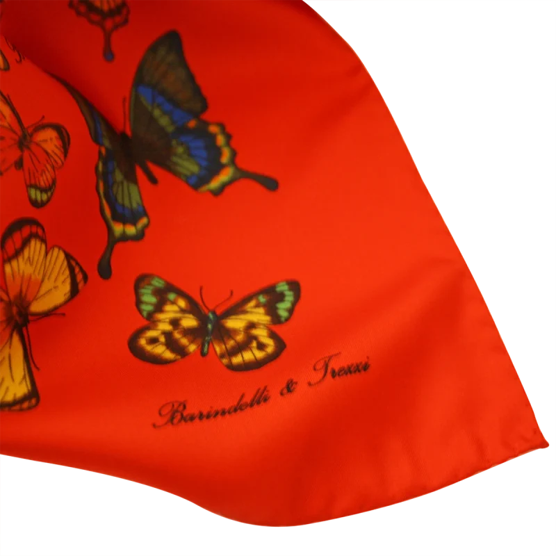 dettaglio delle farfalle colorate su foulard in seta rosso vivo