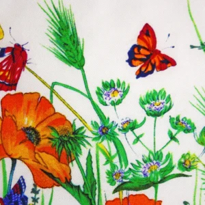 dettaglio della stampa su seta twill con farfalla arancione, fiore di campo e piccoli boccioli verdi