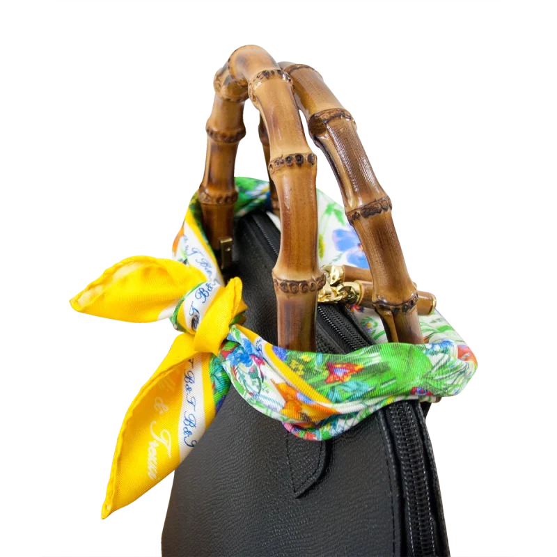 Foulard piccolo in seta gialla con fantasia floreale utilizzato su borsa nera in pelle e bambù