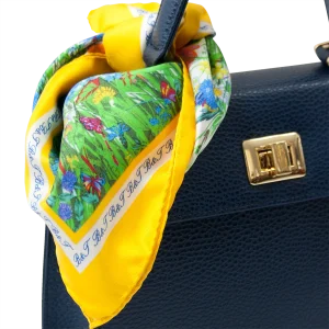Foulard piccolo in seta gialla con fantasia floreale utilizzato su borsa blu in pelle