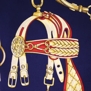 particolare della stampa su seta blu navy con finimenti equestri rossi e dorati