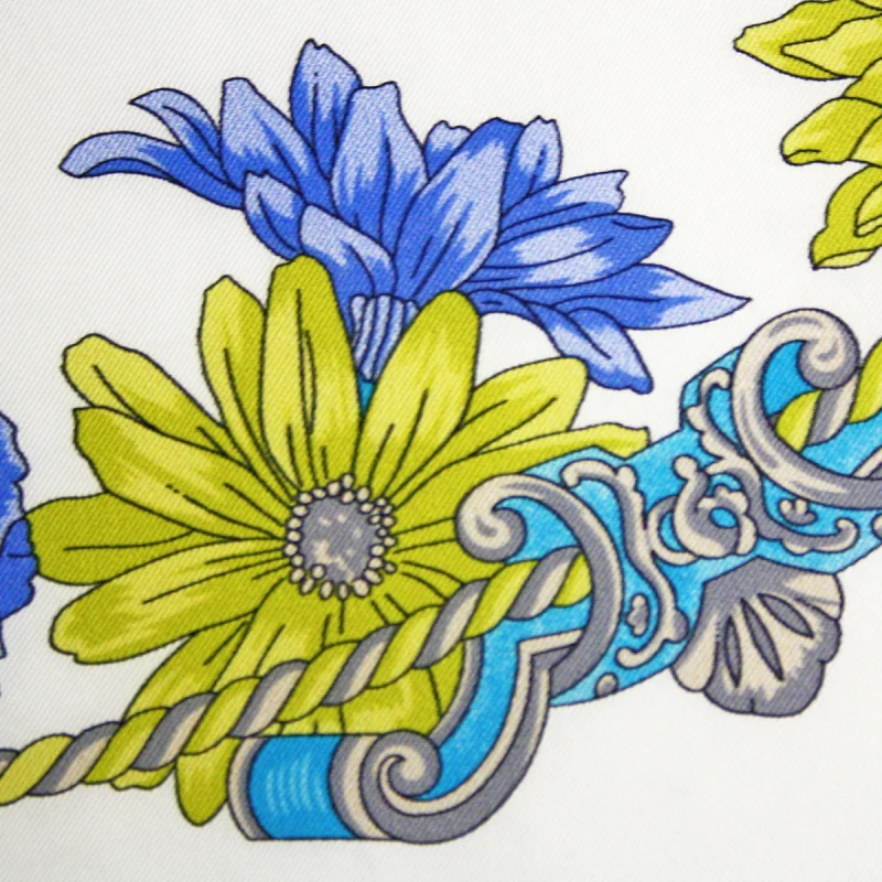 dettaglio foulard in seta con fiori blu e verdi e motivo ornamentale azzurro