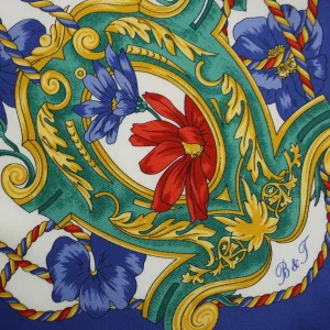dettaglio foulard in seta con decori verdi e dorati fiori rossi e blu