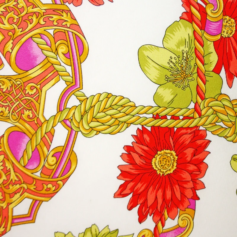 dettaglio foulard in seta con fiori corallo e verdi corde intrecciate e decori rosa