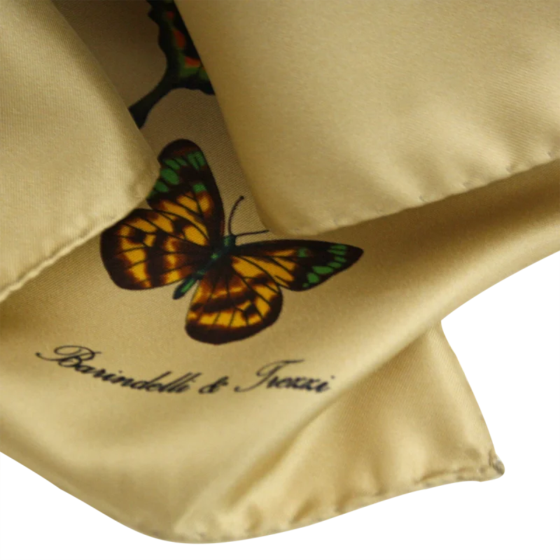 dettaglio della stampa con farfalla colorata su foulard in seta beige sabbia