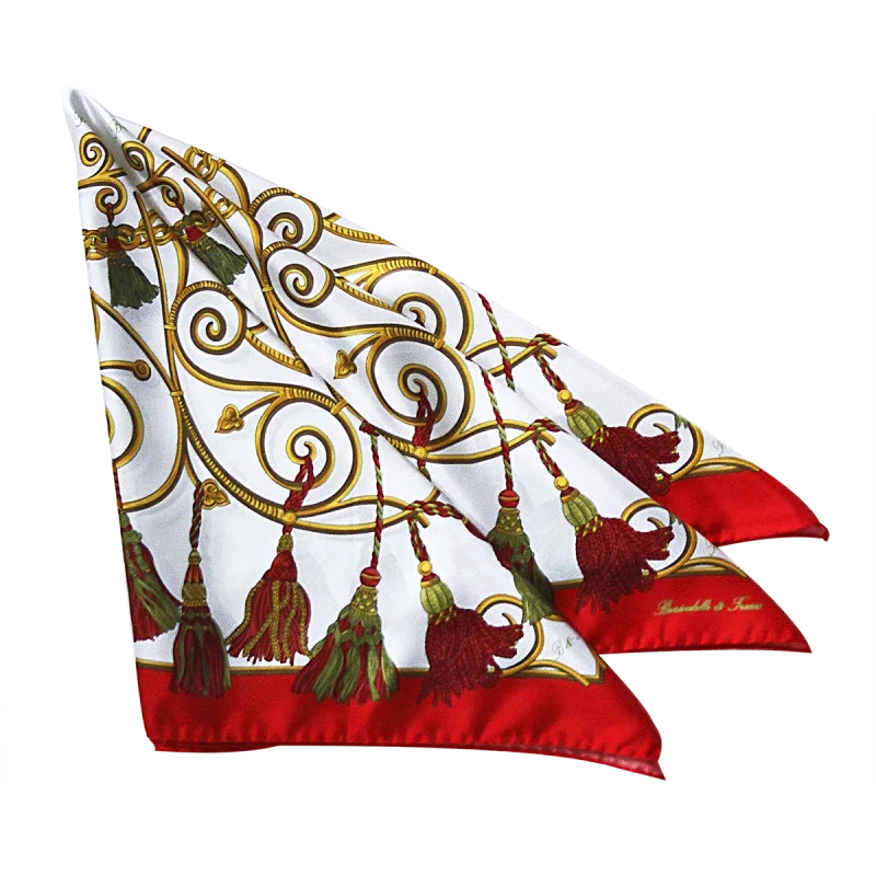 dettaglio foulard in seta con nappine rosse e verdi e bordo rosso