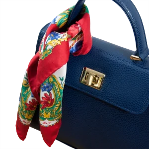 Foulard piccolo in seta rosso rubino con fantasia floreale utilizzato su borsa blu in pelle